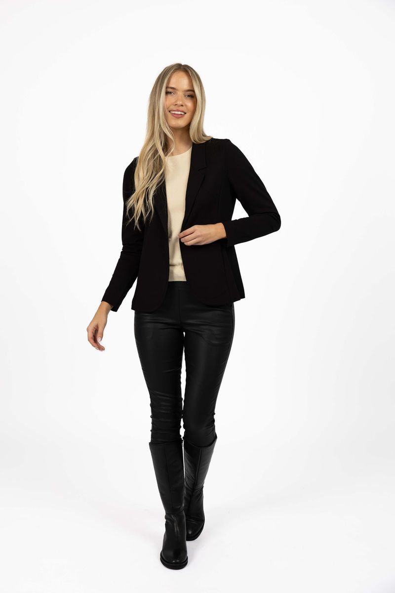 Model in studio wearing Roca Jacket in Black over Mae Jumper in Buttermilk with Status Pants and Stilt Boots, full-length front view 