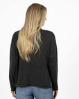 Model in studio wearing Divine Jumper in Charcoal with Ryder Jean, close-up back view  