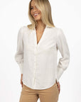 Model in studio wearing Pixie Shirt in White with Fleetwood Cord Pant in Wheat, close-up front view showing button-through front 