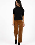 Model in studio wearing Va Va Velour Pant in Camel with Vera Top in Black with black boots, full-length front view 