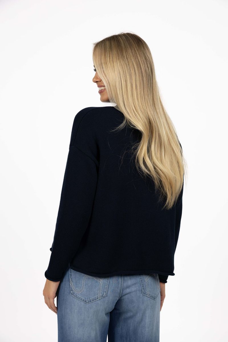 Model in studio wearing Divine Jumper in Navy with Ryder Jean, close-up back view 