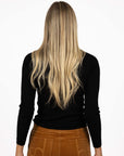 Model in studio wearing Tempo Top in Black with Stitched Luxe Pant in Camel, close-up back view  