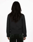 Model in studio wearing Rexie Jumper in Charcoal with Va Va Velour Pant in Khaki, close-up back view shwoing wide ribbed hem 