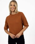 Model in studio wearing Grace Top in Caramel with black Va Va Velour Pant, close-up front view 