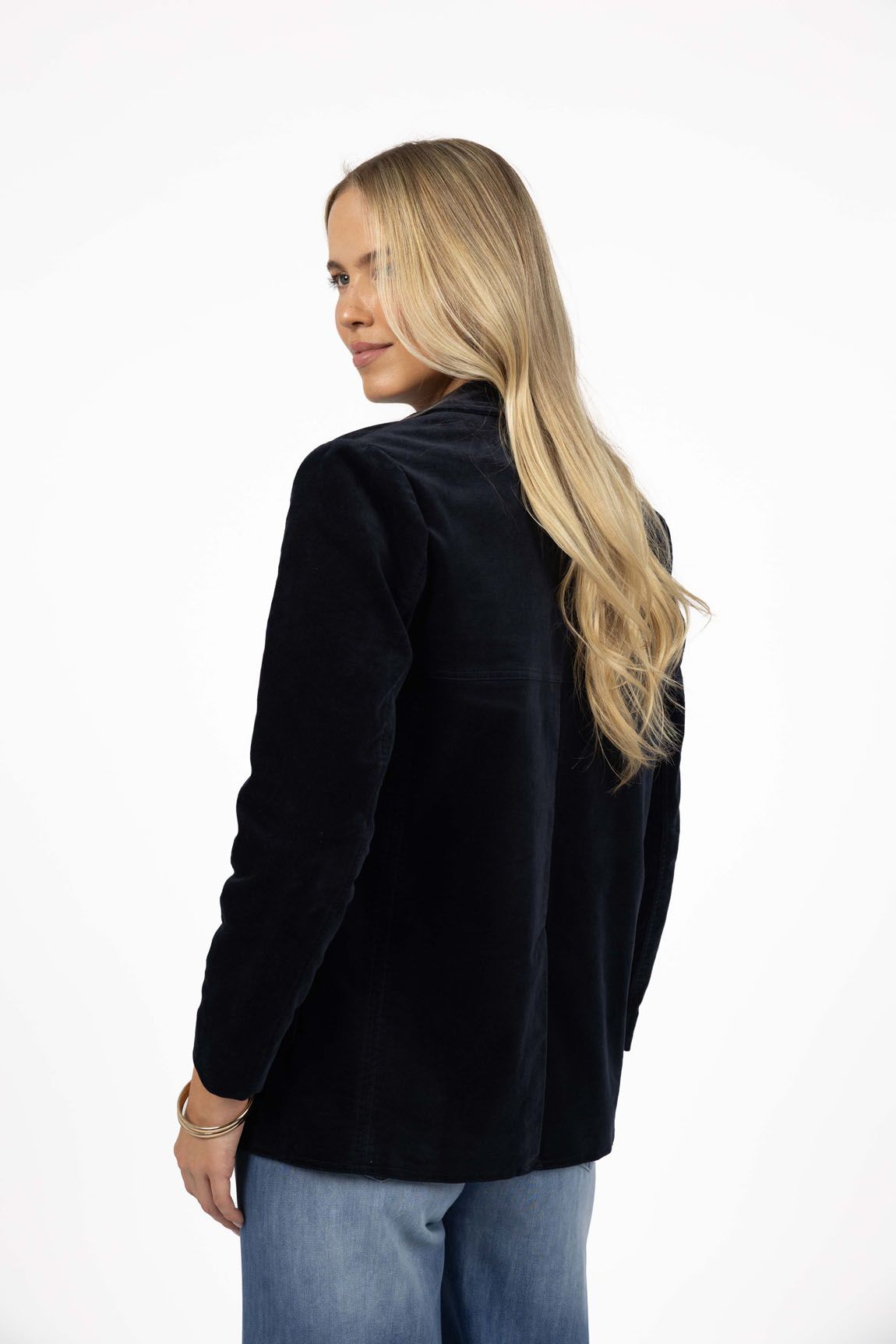 Model in studio wearing Va Va Velour Coat in Navy with Ryder Jean, close-up back view 