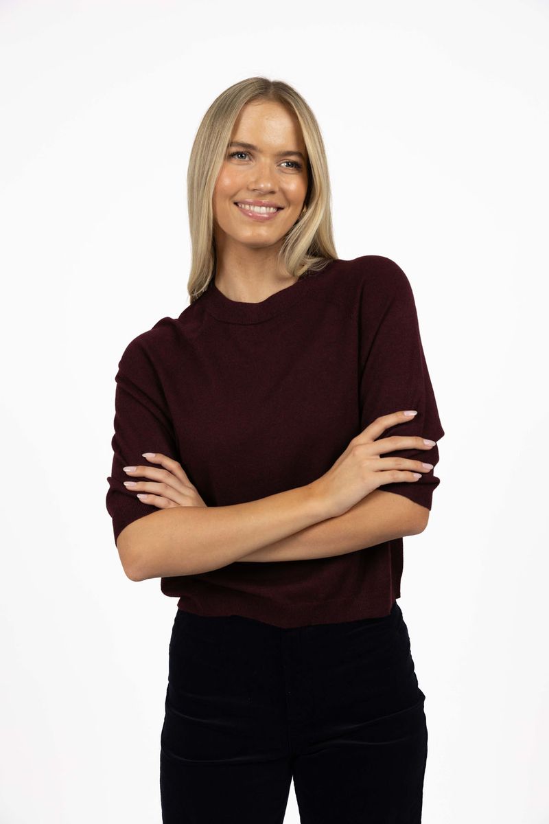 Model in studio wearing Grace Top in Merlot with black Va Va Velour Pant, close-up front view  