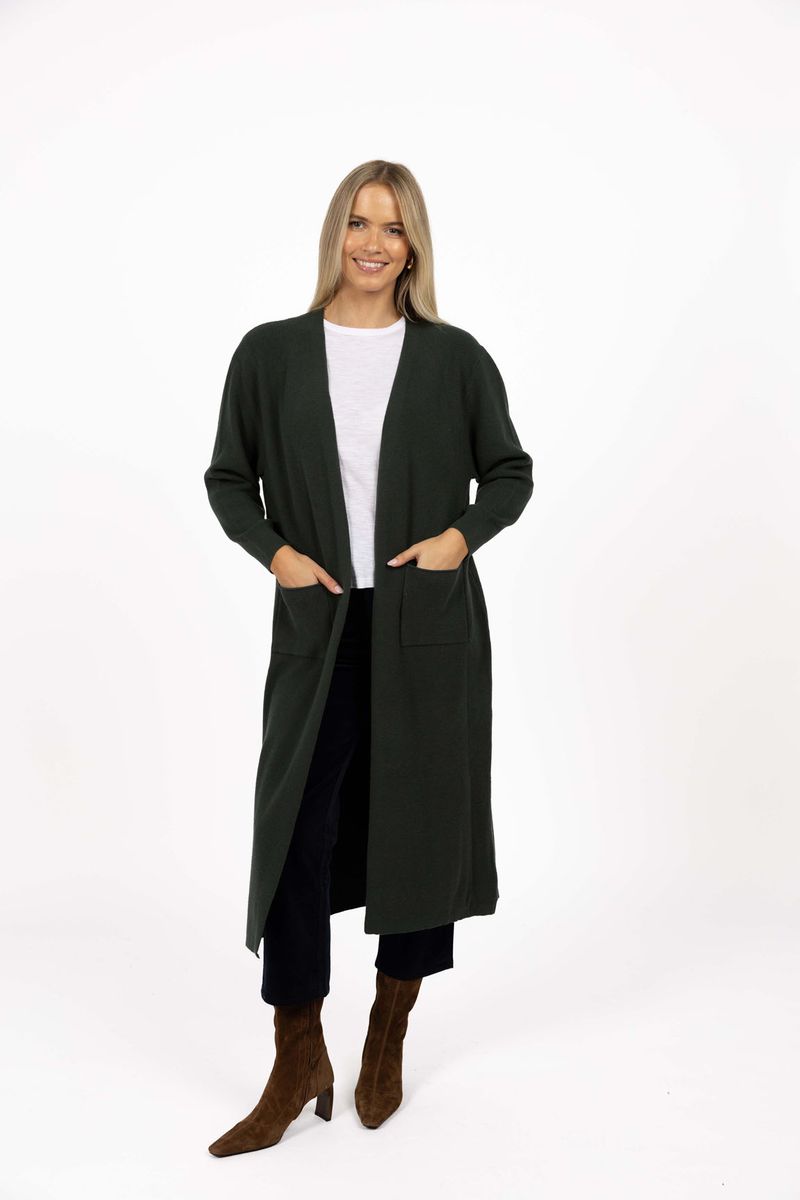 Model in studio wearing Clover Cardi in Khaki over white tee and Va Va Velour Pant in Black with brown boots, full-length front view 