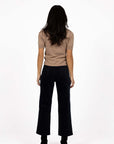 Model in studio wearing Va Va Velour Pant in Navy with Vera Top in Hazelnut and black boots, full-length back view 