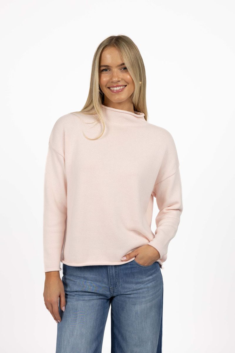Model in studio wearing Divine Jumper in Pink with Ryder Jean, close-up front view with hand in jean pocket 