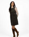 Model in studio wearing Nova Cord Dress in Khaki over the Alana Skivvy in Birch with brown boots, full-length front view 