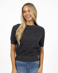 Model in studio wearing Aurora Top in Charcoal with Ryder Jean, close-up front view showing ribbed cinched hem