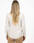 Model in studio wearing Pixie Shirt in White with Fleetwood Cord Pant in Wheat, close-up back view showing round hem 