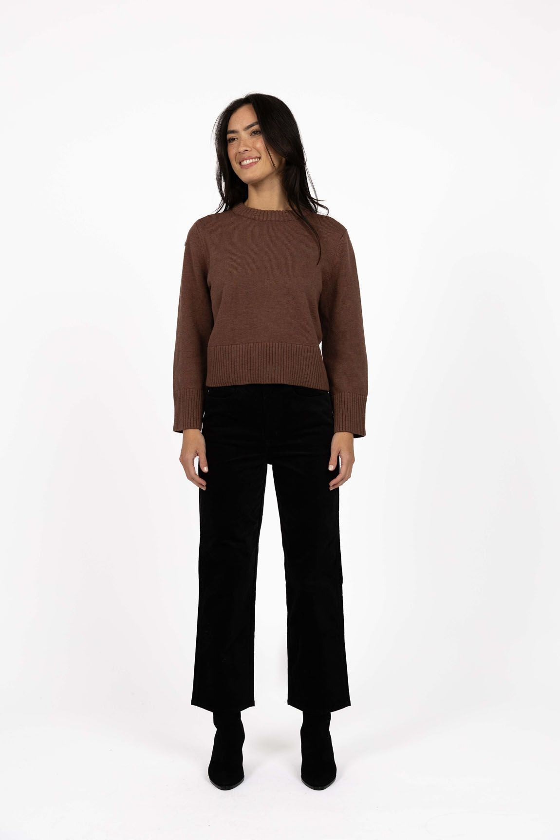 Model in studio wearing Va Va Velour Pant in Black with Rexie Jumper in Mocha and black boots, full-length front view  