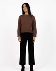 Model in studio wearing Va Va Velour Pant in Black with Rexie Jumper in Mocha and black boots, full-length front view  